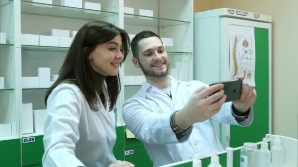 Забавная команда фармацевтов делает селфи-картинки в аптеке — стоковое видео