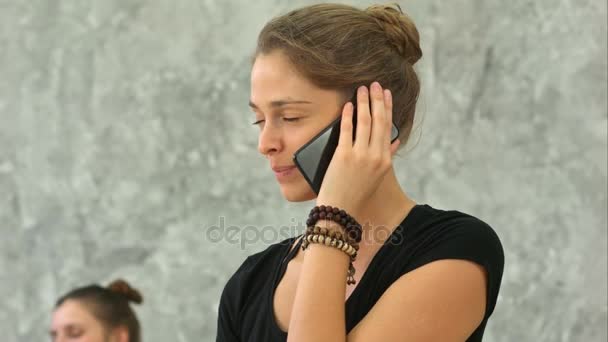 Yoga-instructeur spreekt over de telefoon na de training — Stockvideo