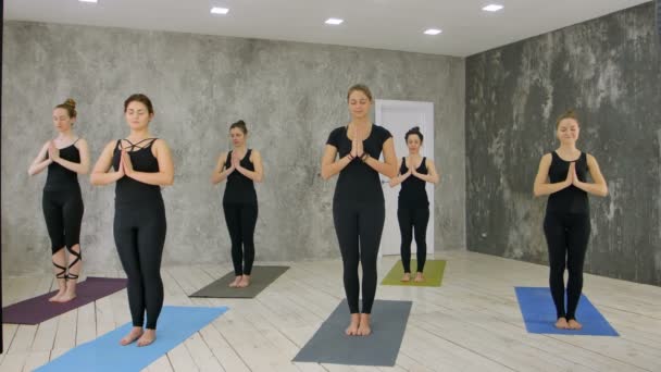 Kvinnliga tränare med klass står i namaste posera på yogaklass — Stockvideo