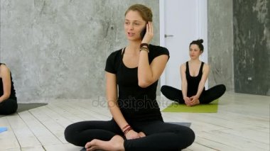 Yoga eğitmeni telefonda eğitimden sonra konuşuyor.