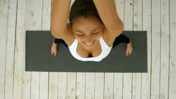 Профіль красивої молодої жінки, що робить близнюка в класі йоги — стокове відео