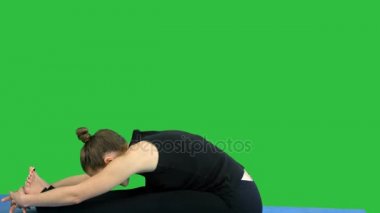 Mindere bacak germe, pratik yoga bir yeşil ekranında, Chroma Key genç kadın