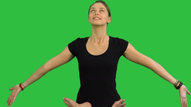 Young woman sitting in lotus yoga pose practicing meditation on a Green Screen, Chroma Key — Stock Video