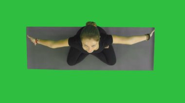 Çalışma dışarı, yoga yaparken çekici genç kadın egzersiz, yarım Lotus otururken, meditasyon, kamera bir gülümseme ile yeşil ekranda Chroma Key arıyorsunuz Namaste içinde Ardha Padmasana ile palmiyeler