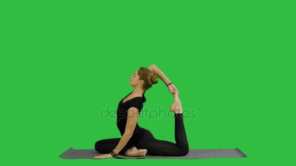 Νεαρή όμορφη γυναίκα να κάνει γιόγκα θέτουν, τεντώνοντας το κορμί της σε μια πράσινη οθόνη, Chroma Key — Αρχείο Βίντεο
