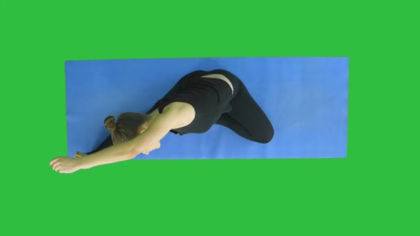 Młoda kobieta, stretching nóg na matę na zielony ekran, Chroma Key sprawny — Wideo stockowe