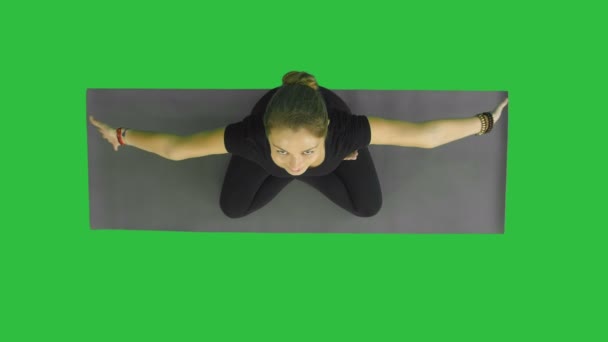 Séduisante jeune femme travaillant, faisant de l'exercice de yoga, Assis en demi Lotus, Ardha Padmasana avec les paumes à Namaste, méditant, regardant la caméra avec un sourire sur un écran vert, Chroma Key — Video