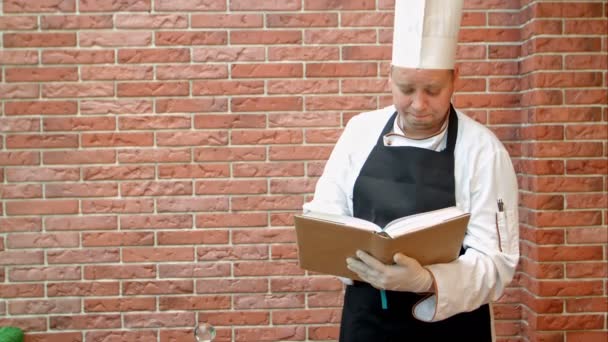 Chef cozinheiro segurando receitas livro pensando o que cozinhar — Vídeo de Stock