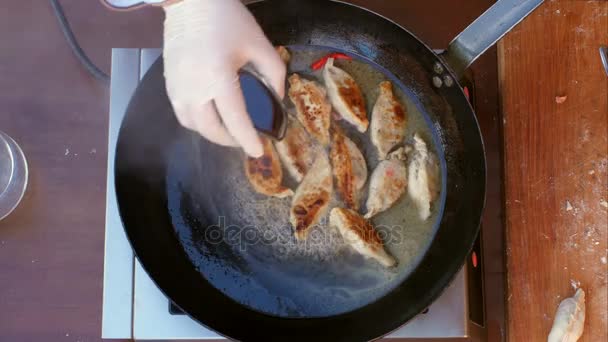 Ptting 盐和胡椒来饺子在油在锅里煎 — 图库视频影像