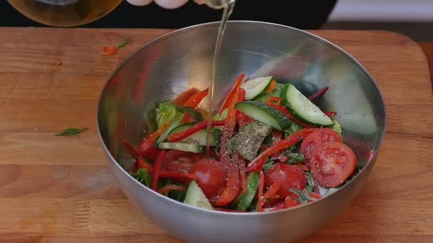 Pouring olive oil into fresh summer salad — Stock Video