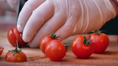 Masadaki tabaklar için domates kesiyorum.