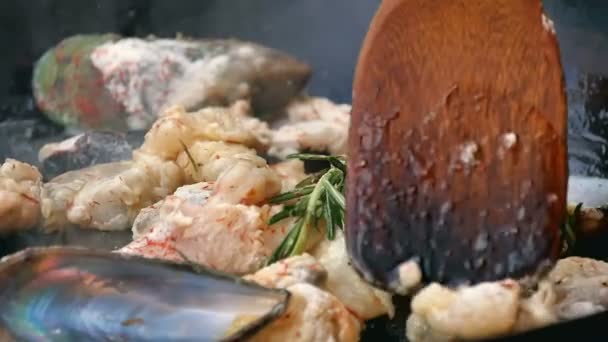 Tavada raket ile deniz ürünleri yemek karıştırma — Stok video