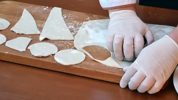 Recorte círculos da massa de farinha de biscoito crua rolou a costura em uma tábua de madeira — Vídeo de Stock