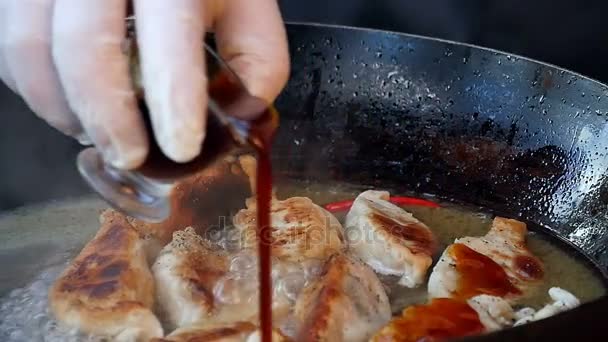 Sauce über gebratene Knödel in Pfanne gießen — Stockvideo