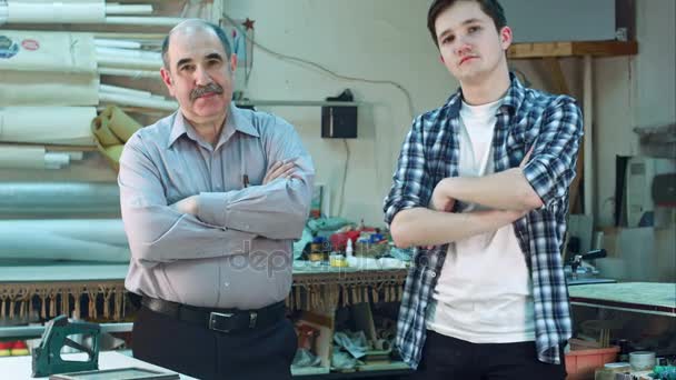 Retrato de dos trabajadores, de pie en el taller y mirando seriamente a la cámara — Vídeos de Stock