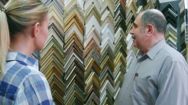 Neşeli gülümseyen kıdemli adam çalışan müşteri atelier çerçevelerde hakkında sohbet
