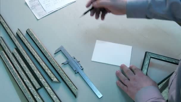 Measuring the size of frame, writing down notes in workshop — Stock Video