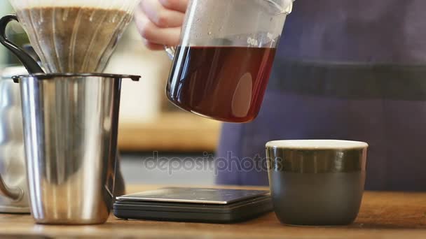 Heißen Kaffee in eine schwarze Tasse gießen — Stockvideo