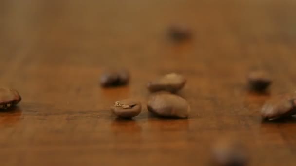 Granos de café sobre mesa de madera — Vídeo de stock