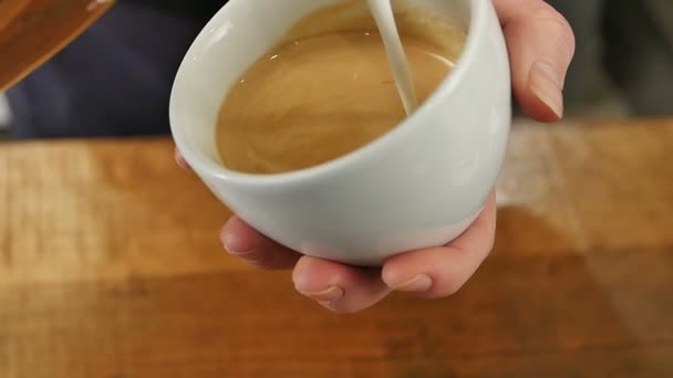 Выливание молока в кофе — стоковое видео