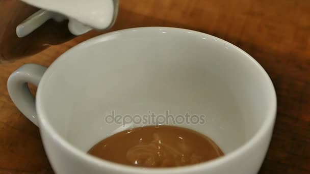 Hälla stream mjölk i en kopp kaffe — Stockvideo