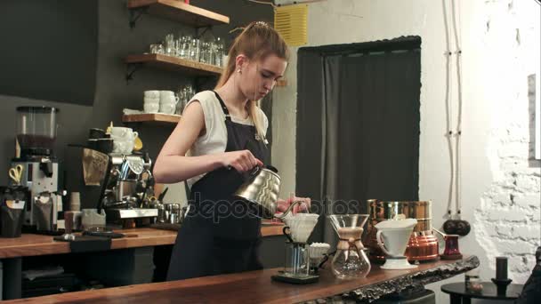 Νεαρή γυναίκα barista σε μοντέρνο café σύγχρονο καφενείο χύνει βραστό νερό πάνω από λόγους καφέ κάνοντας χύσει πάνω από καφέ στάγδην — Αρχείο Βίντεο
