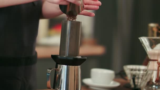 Barista fügt gemahlenen Kaffee hinzu und gießt heißes Wasser ein — Stockvideo