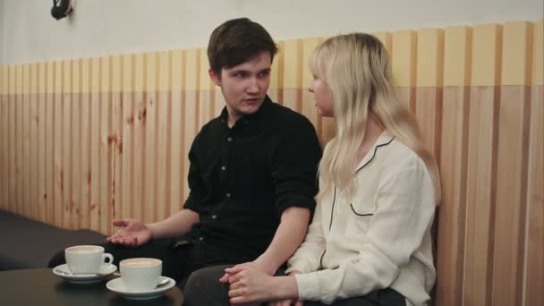 Bir kahve dükkanında konuşuyor ve öpüşme, aşık genç çift portresi — Stok video