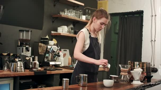 Barista szakadó kávé és a tej egy csésze a kávézóban — Stock videók