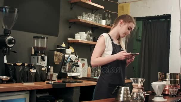 Barista femenina tomando fotos de cofee preparado con smartphone — Vídeo de stock