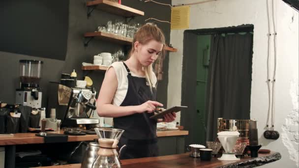 Ευτυχισμένος barista ή σερβιτόρος στην ποδιά με υπολογιστή tablet pc στο μπαρ ή καφέ — Αρχείο Βίντεο