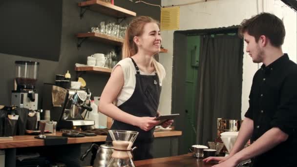 Mujer barista hablando con el cliente en un café, tomando el orden — Vídeo de stock