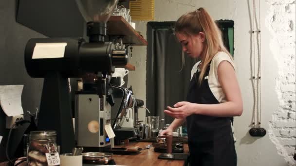 Mooie jonge vrouwelijke barista koffie korrels gewicht op een schaal voor het brouwen van een kopje koffie — Stockvideo