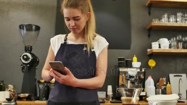 Cep telefonu iş yerinde kullanarak memnun kadın barista