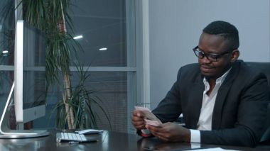 Afro işadamı masa ofis oturma para sayma