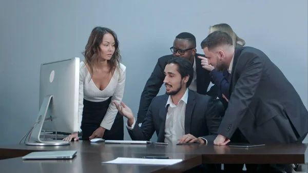 Groupe de gens d'affaires multiraciaux autour de la table de conférence regardant l'ordinateur portable et parlant entre eux — Photo