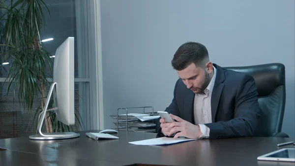 Pensativo hombre de negocios caucásico dispositivo de retención y pantalla táctil — Foto de Stock