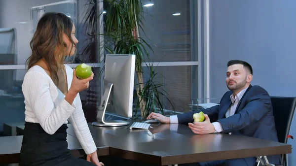 Deux employés de bureau font une pause, préparent des pommes vertes et parlent au bureau — Photo