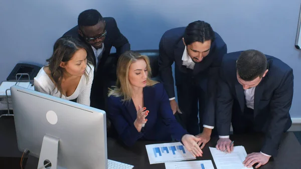 Vista de alto ángulo del equipo creativo de pie alrededor de la mesa discutiendo ideas de negocios — Foto de Stock