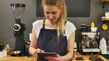 Gülümseyen ve neşeli barista dijital tablet için iş kullanma