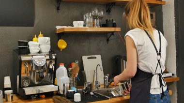 Genç kadın barista işyerinde bulaşık