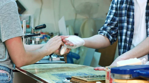 Женщины аккуратно перевязывают руки работнице травмированной руки после несчастного случая — стоковое фото