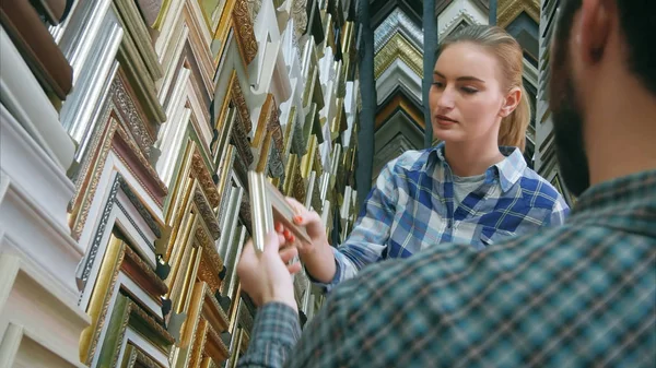 Operaio maschio che chatta con il cliente sui dettagli della cornice in atelier — Foto Stock