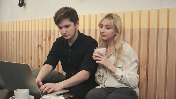 Pár, pracují na notebooku, pití kávy v kavárně — Stock fotografie
