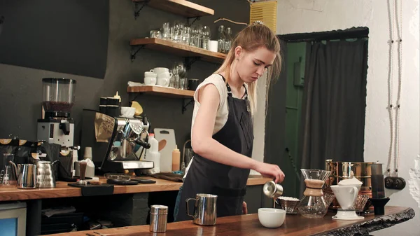 Бариста наливает кофе и молоко в чашку кофе в кафе — стоковое фото