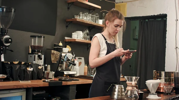 Barista femenina tomando fotos de cofee preparado con smartphone — Foto de Stock