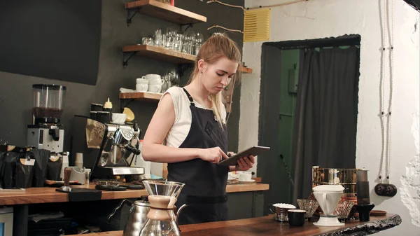 Barista feliz ou garçom em avental com computador tablet pc no bar ou café — Fotografia de Stock