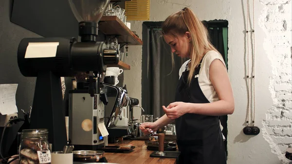 Csinos, fiatal női barista súlyú szemes kávé skálán előtt sör egy csésze kávé — Stock Fotó