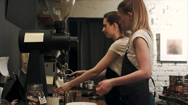Dos baristas jóvenes trabajando en la cafetería, pareparing café — Foto de Stock