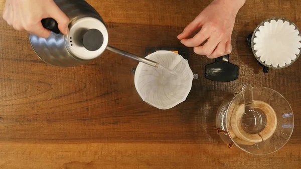 Бариста льет воду на кофейную гущу с фильтром — стоковое фото